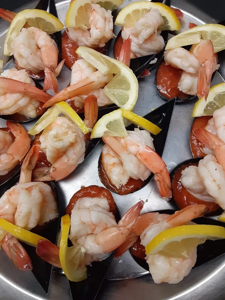 Shrimp cocktail with lemon on silver platter