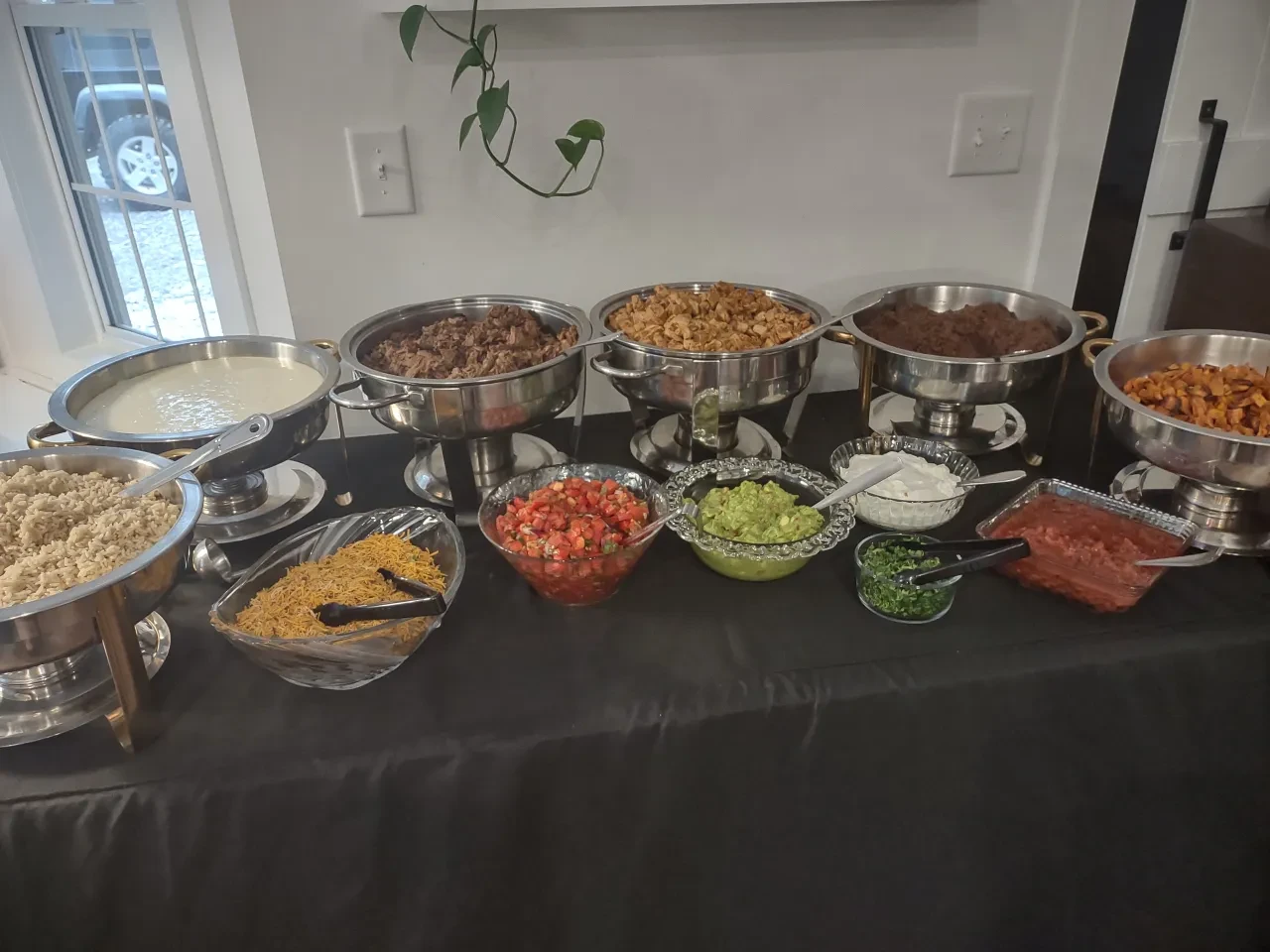 Full taco buffet spread with chafing dishes and toppings