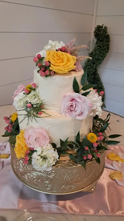 Three-tier wedding cake with fresh flowers